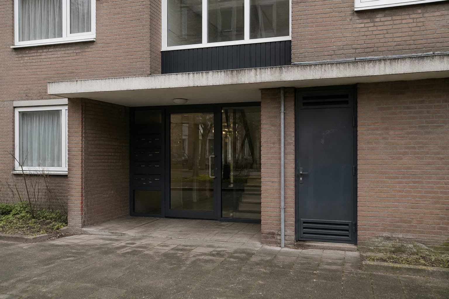 Entree van een woongebouw in een alledaagse Nederlandse wijk.