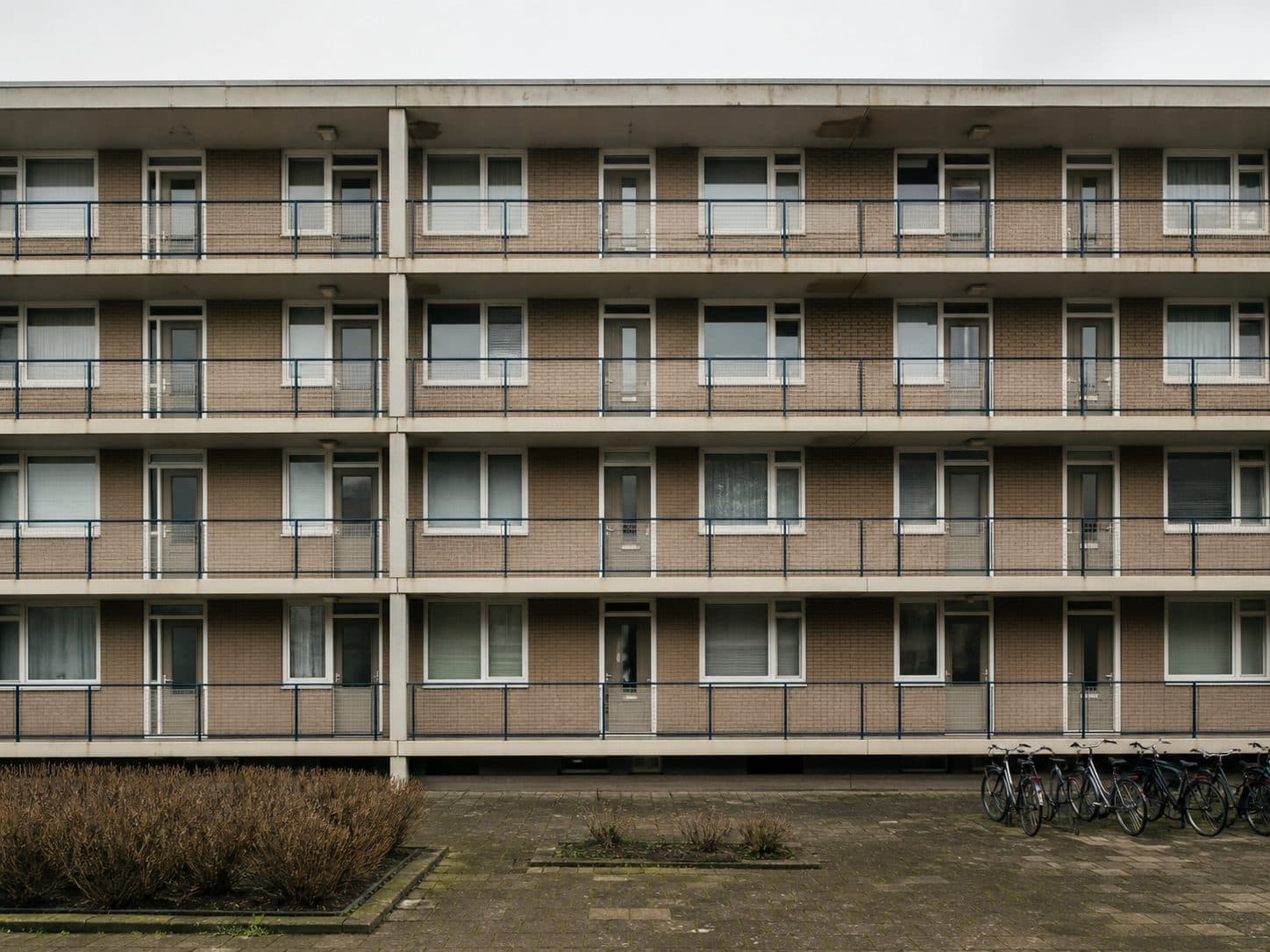 Galerijflat met herhalende woningen en toegangen.