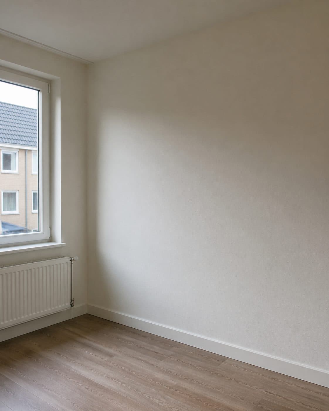 Afgewerkte woonruimte met geschilderde wand en radiator.